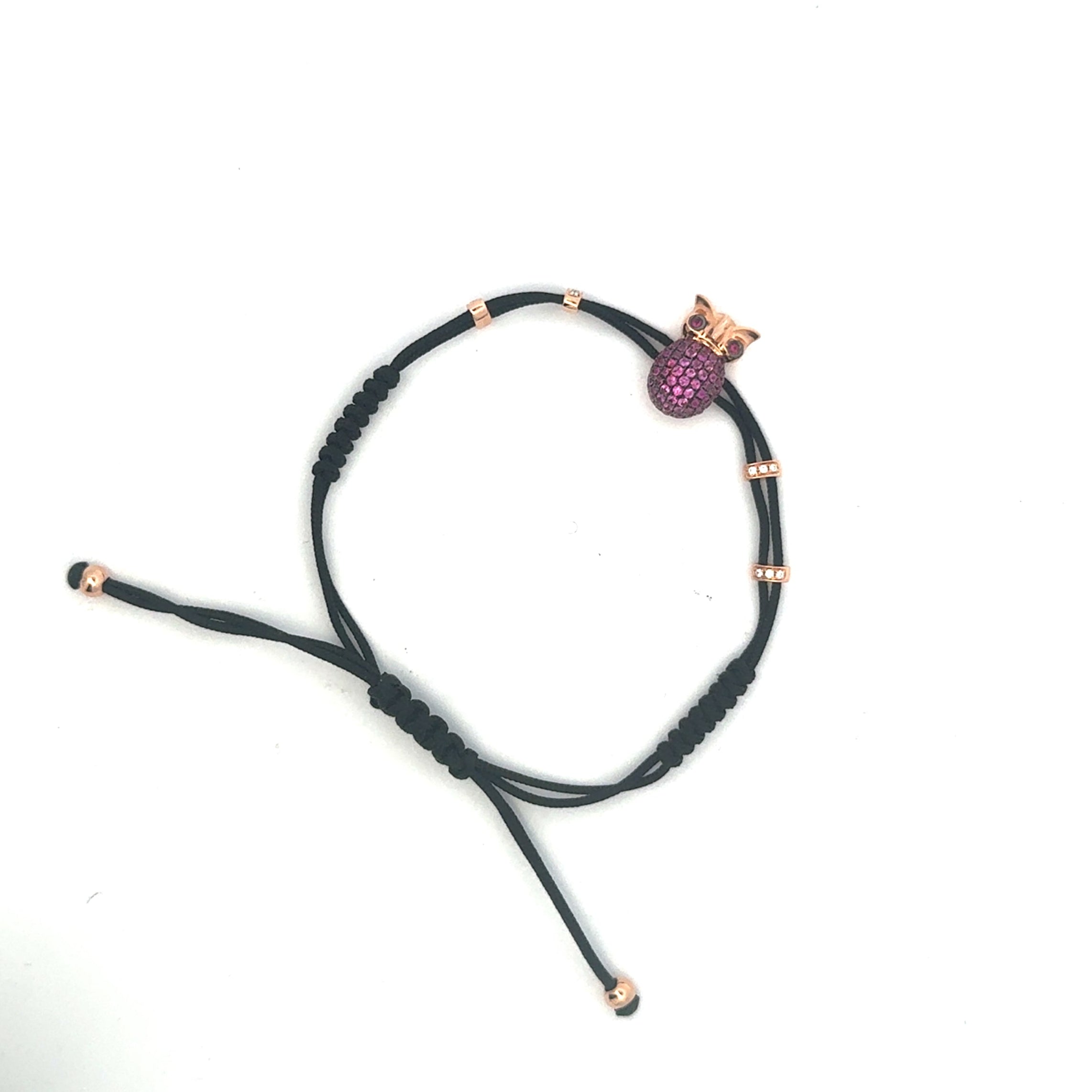 Black braided bracelet with a purple bead and gold accents on a white background